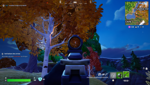 Vue subjective dans le jeu Fortnite : un fusil est braqué vers un érable