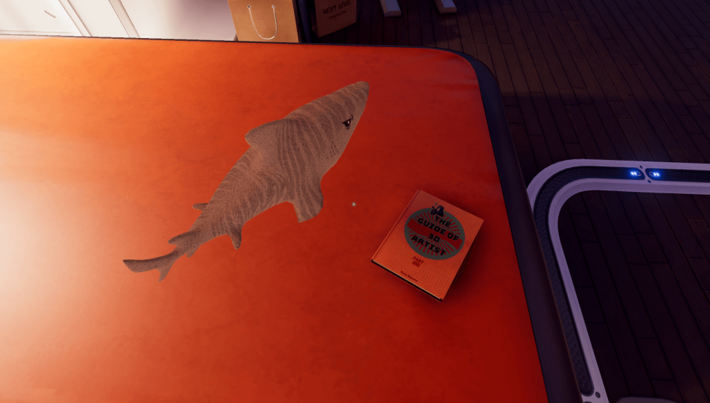 Une peluche de requin (référence à Fins - l'aileron) et un livre sur la création 3D sont posés sur le lit de l'appartemant
